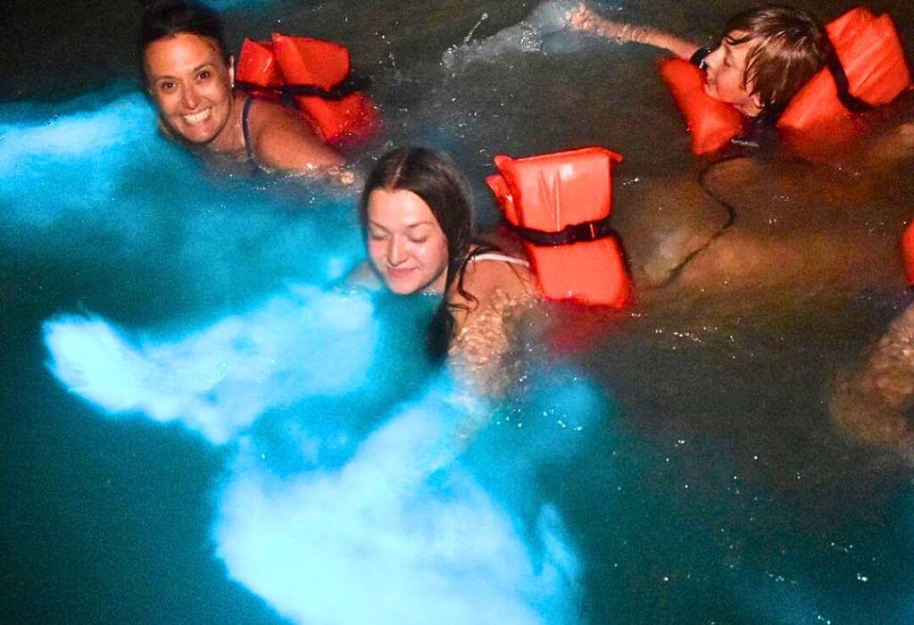 Luminous Lagoon Glistening Waters Tour in Jamaica with three people swimming in glistening water.